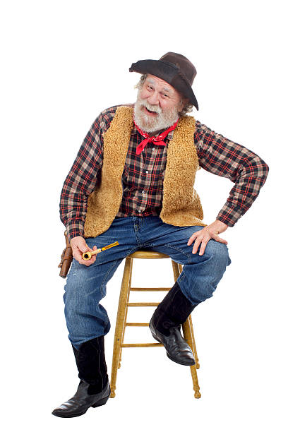 istock Cheerful old cowboy sits holding corn cob pipe 177532219