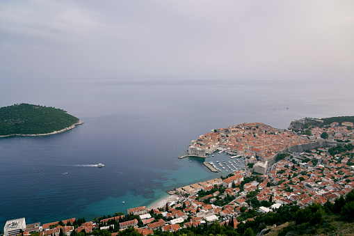 View from the mountain to the yacht sailing on the sea to the port of Dubrovnik. Croatia. High quality photo