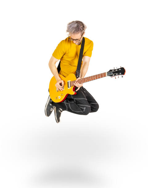 jovem adulto masculino pulando e tocando uma guitarra elétrica - isolated on white studio shot guitar young men - fotografias e filmes do acervo