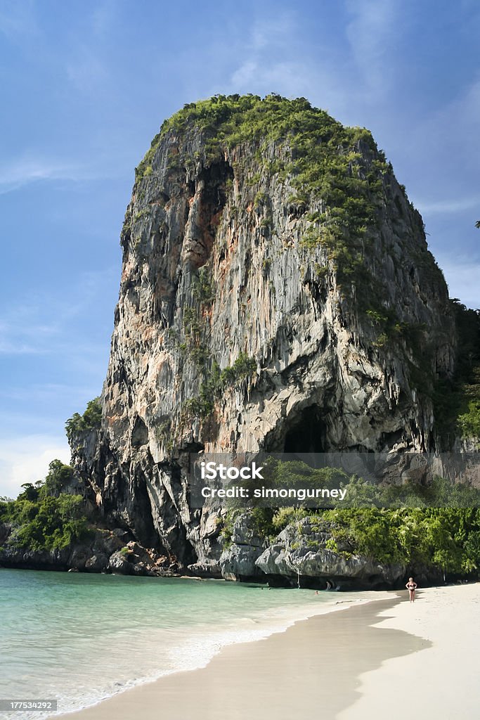 railay beach karst formations thailand tourists on the white sand of railay beach overlooked by large karst rock formations in krabi thailand Adult Stock Photo