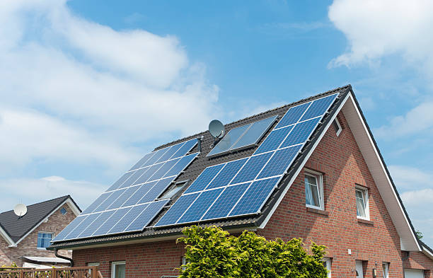 Multiple solar panels installed on a steep house roof stock photo