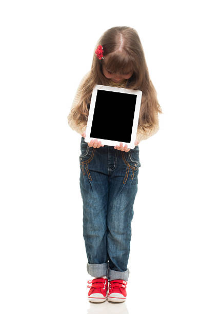 istock cute little girl posing in studio with white tablet gadget 177535655