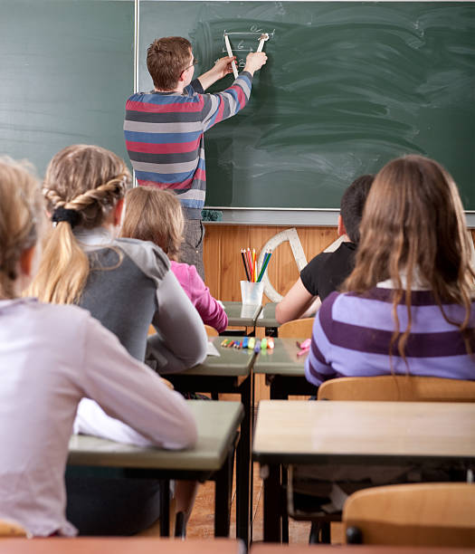 Junge männliche Lehrer erklären Mathematik an Tafel – Foto