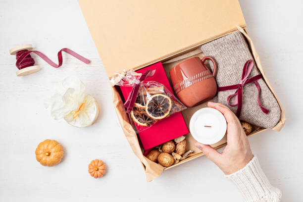istock Preparing care package with warm socks, book, coffee cup, aroma spices. Personalized eco friendly basket for fall, winter holidays, christmas, wishig recovery to family, friend. Get well soon gift box 1775371207