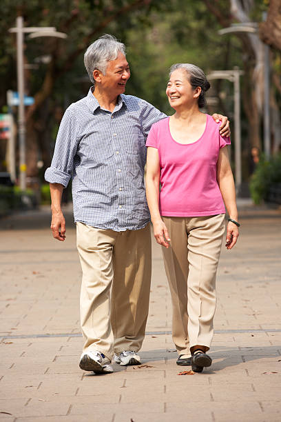 chinês casal sênior, caminhando no parque - couple mature adult action walking - fotografias e filmes do acervo