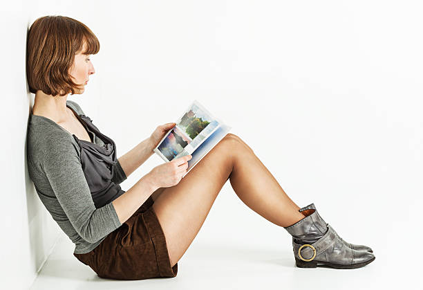 mulher sentada no chão com livro - wall profile imagens e fotografias de stock