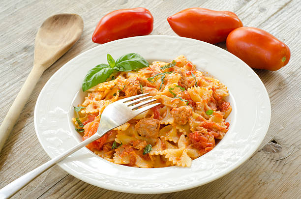 Farfalle topped with tomato sauce,tuna and basil stock photo