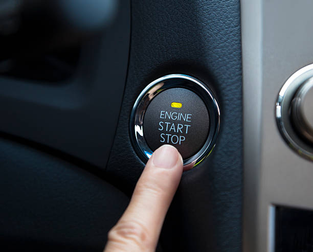 finger pressing the engine start stop button - startknop stockfoto's en -beelden
