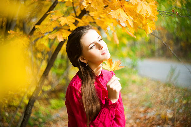 Woman portrait in autumnal park.Shot made on Helios 44-2 lens with characteristic bokeh.