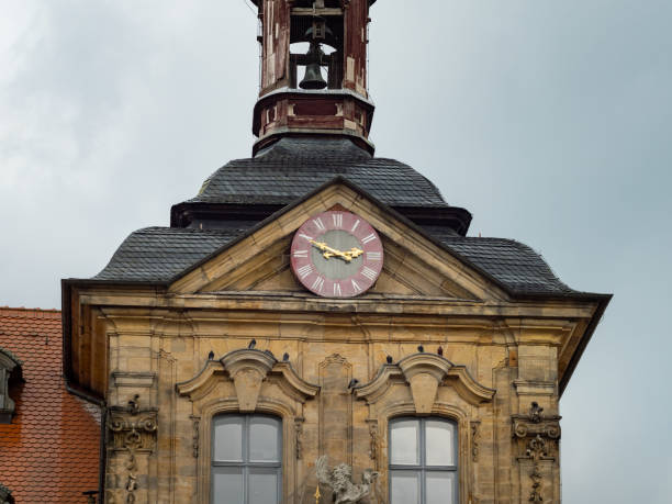 Bamberg, Clock on the town hall building in a close up view. Afternoon time on the facade of the historical house. The ancient exterior is a tourist attraction.