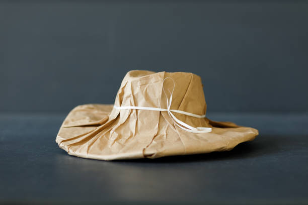 A brand new hat wrapped in rustic beige craft paper. Black Friday shopping concept. stock photo
