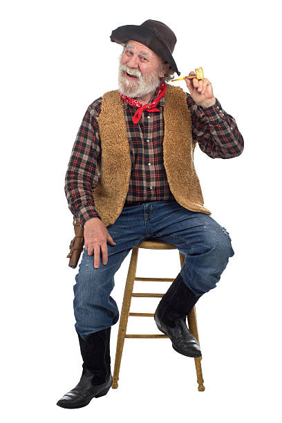 istock Cheerful old cowboy sits on stool with corn cob pipe 177540789