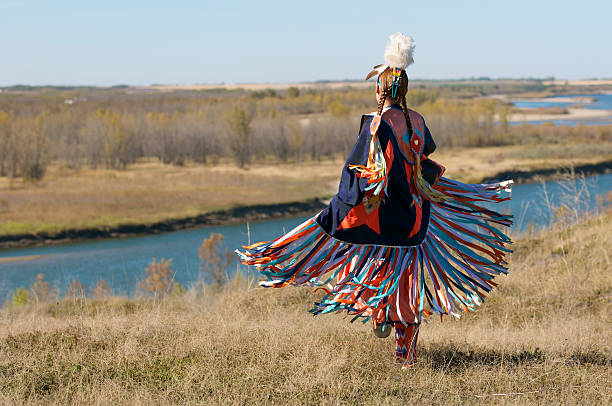 Women's Fancy Shawl Dance Movement First Nations Women performing a Fancy Shawl Dance in a grass field with a river background traditional clothing photos stock pictures, royalty-free photos & images