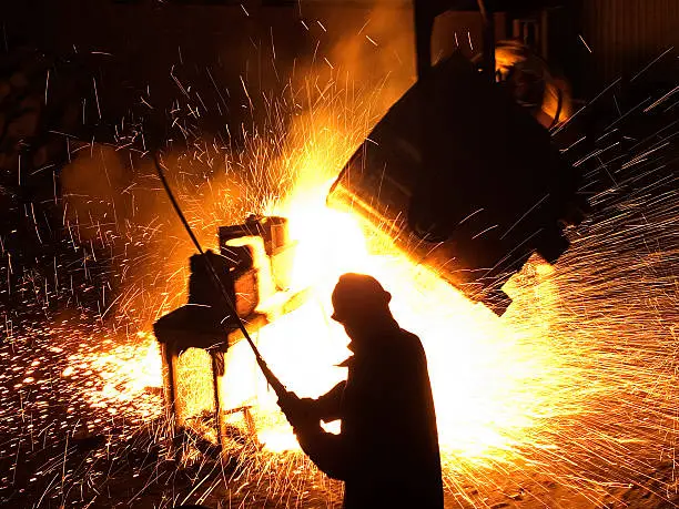 A worker pours steel at a foundry.