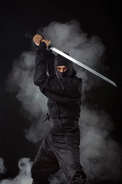 Ninja with sword at night in smoke background