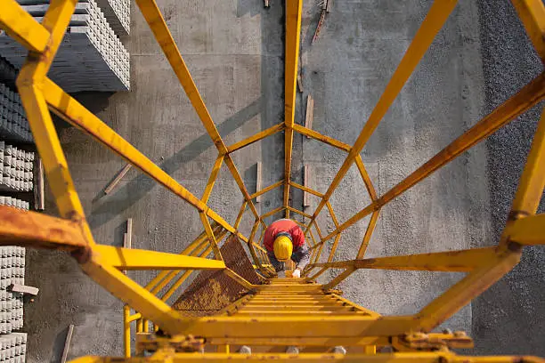 A man climbing gantry crane ladder.