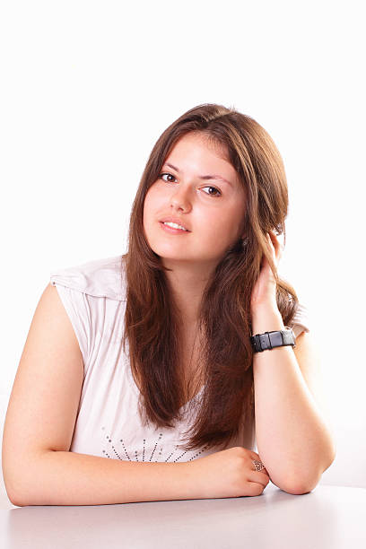 Beautiful young girl sitting in the studio stock photo