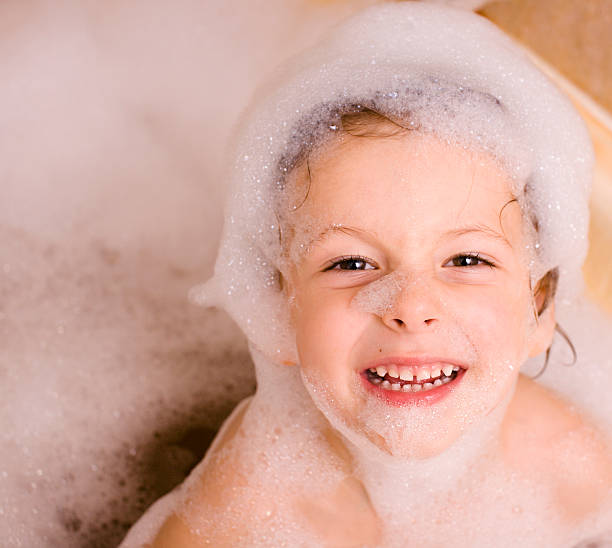 mignon petit garçon dans la salle de bain en mousse - soap sud water froth bubble photos et images de collection