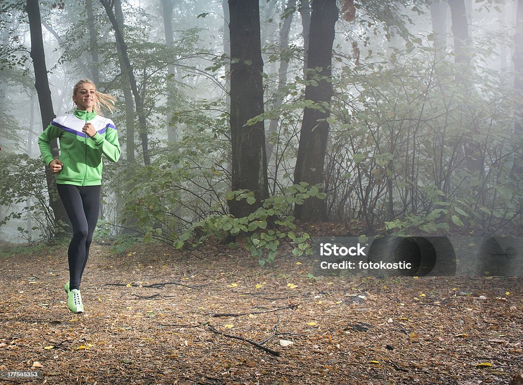 girl jogging girl jogging in autumnal woodland with fog Active Lifestyle Stock Photo