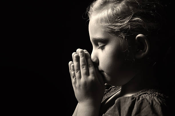 молиться ребенка. - saying grace стоковые фото и изображения