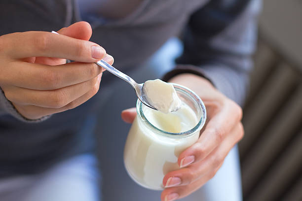 아름다운 젊은 여성 식사 야쿠르트 집에서요 - yogurt 뉴스 사진 이미지