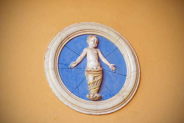 Old effigy of Child in swaddling clothes representing the Nativity at the entrance to an old gynecological ward. Vignetting voluntary.
