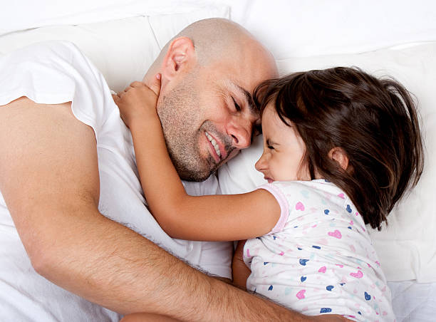 istock father and daughter playing in parents bed 177546387