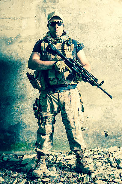 Portrait of Modern Contractor Standing Tall with Assault Rifle stock photo