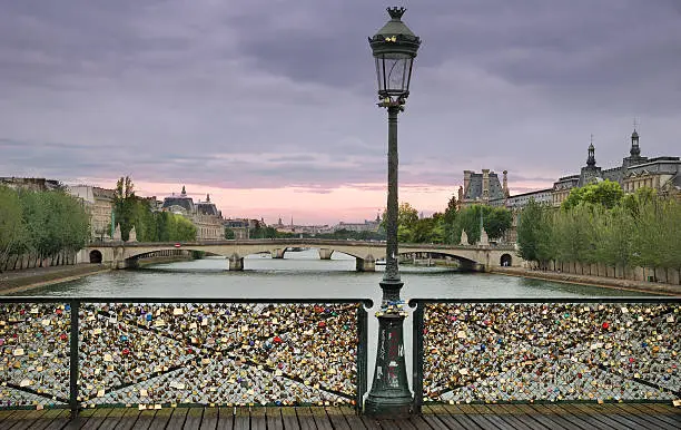 "Love padlocks on the bridge Pont des Arts across river Seine in Paris, France."