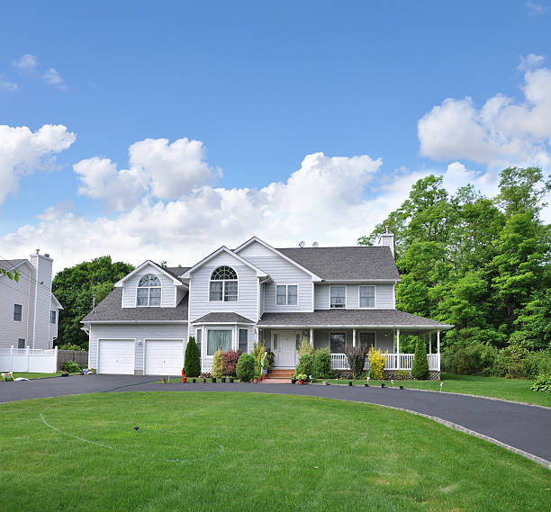 Suburban Home with circular blacktop driveway Beautiful landscaped suburban home with blacktop circular driveway blue sky day with clouds hosta photos stock pictures, royalty-free photos & images