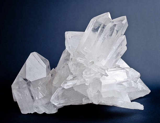 Big quartz crystals Large crystals of white quartz on dark blue background quartz stock pictures, royalty-free photos & images