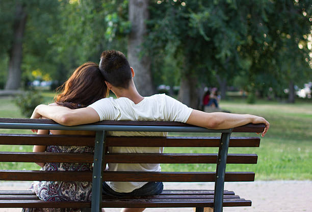 istock Romantic young couple sitting on bench in the park, 177549905