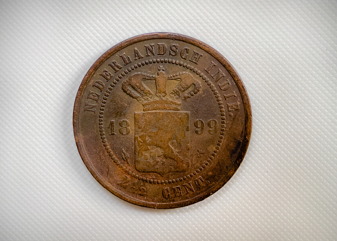 Old Indonesian coins from 1899 on a white background.