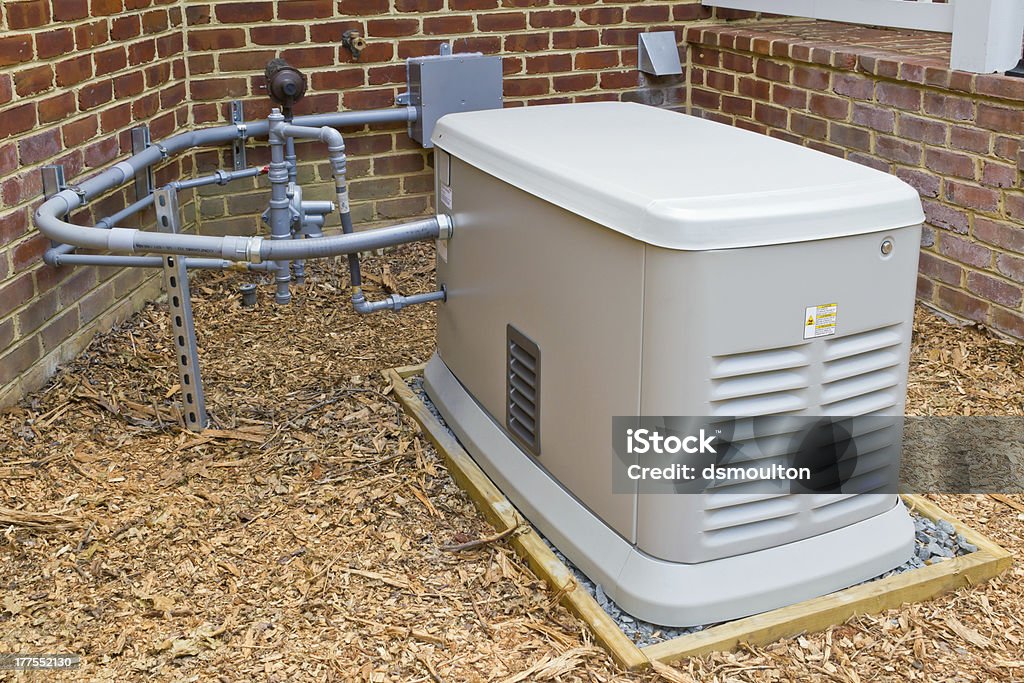 Emergency Home Electricity Generator A home generator that provides electricity during a power outage.  It is connected to a propane gas supply. Generator Stock Photo