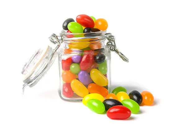 "A candy jar overflowing with jellybeans, shot on a white background"