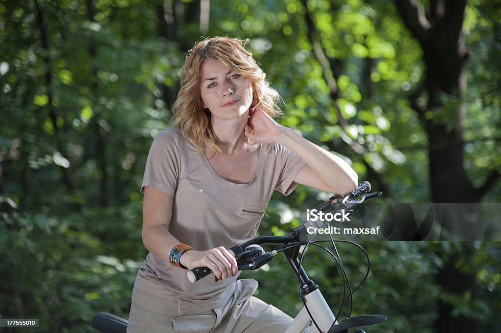 Girl with a bicycle Beautiful young girl with a bicycle in the park Active Lifestyle Stock Photo