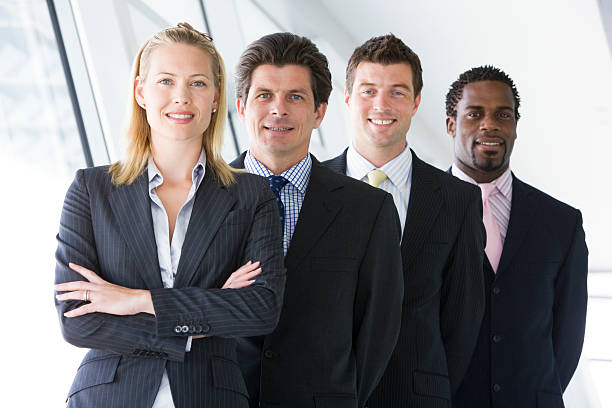 istock Four businesspeople standing in corridor smiling 177556537