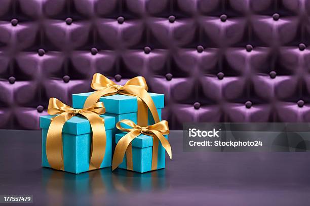 Present In Front Of A Button Tufted Background Stock Photo - Download Image Now - Abstract, Advent, Backgrounds