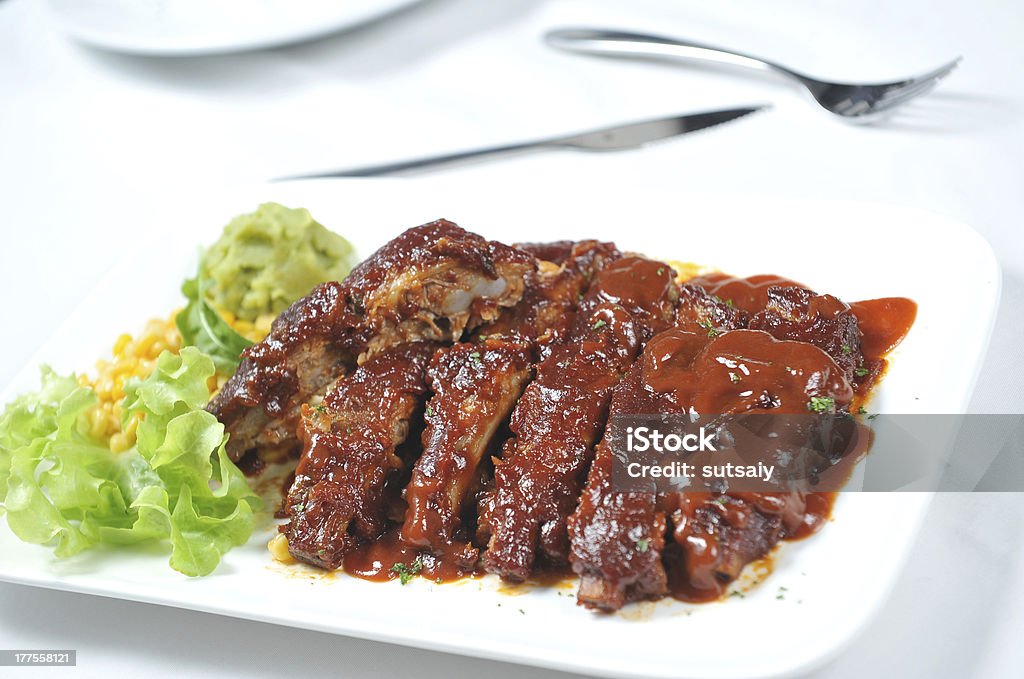 Closeup of barbecued pork ribs and vegetables Barbeque with sauce Beef Stock Photo