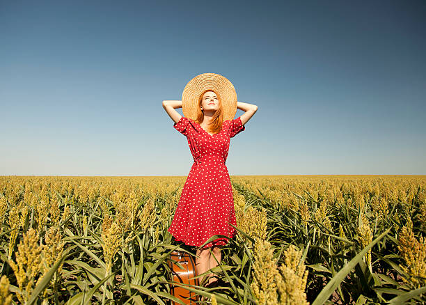 istock Redhead girl with suitcase at corn field. 177559120