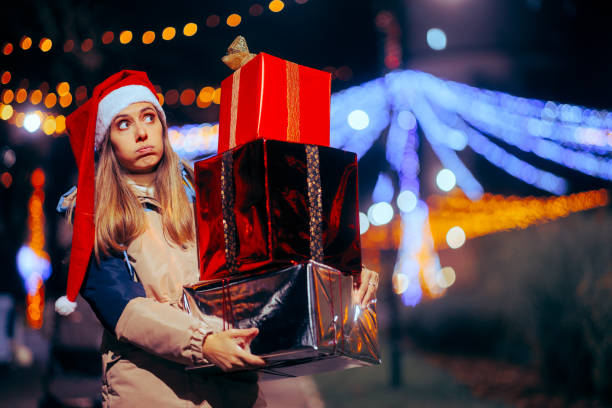 Femme de Noël fatiguée tenant une grande pile de boîtes-cadeaux - Photo
