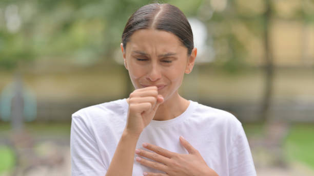 sick hispanic woman coughing while standing outdoor - 15803 imagens e fotografias de stock