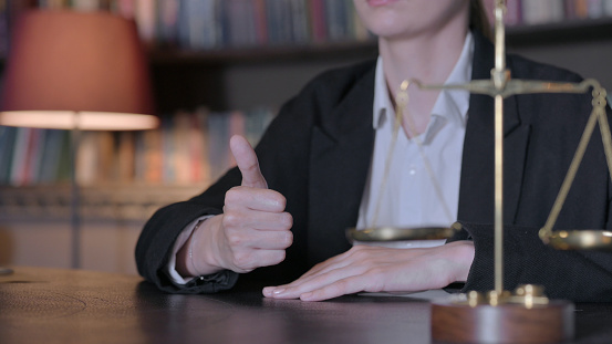 Close Up of Thumbs Up by Female Judge in Court, Scale of Justice