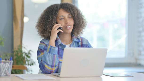 istock Young African Woman Talking on Phone at work 1775663356