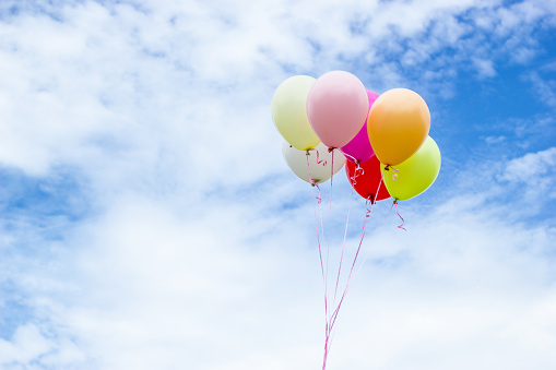 Colorful group balloons with a background of clouds and sky beautiful.