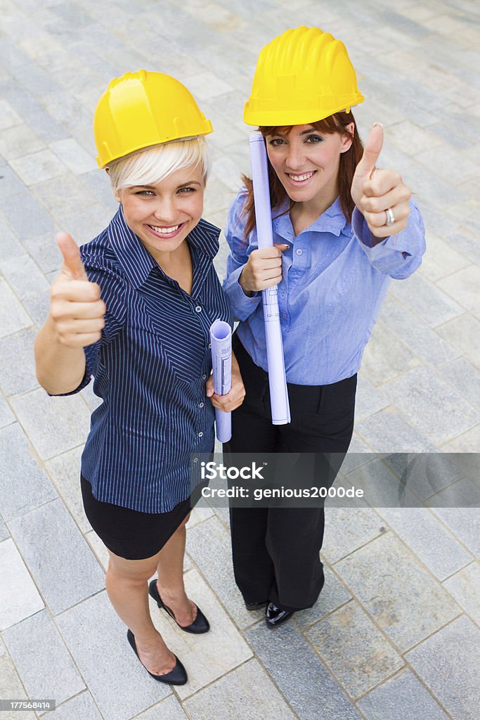Женский constructors, делая Жест позитивные пальца, улыбающегося - Стоковые фото Архитектор роялти-фри