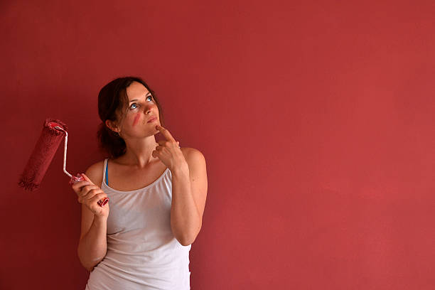 A lady wondering about her paint job stock photo