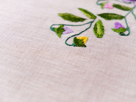 Embroidery on bright background. Soft focus. Close up. Copy space.