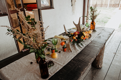 boho style in wedding decoration, table decorated in rustic style, rustic house, flowers horns tableware on the table, eco style, table setting, Scandi style