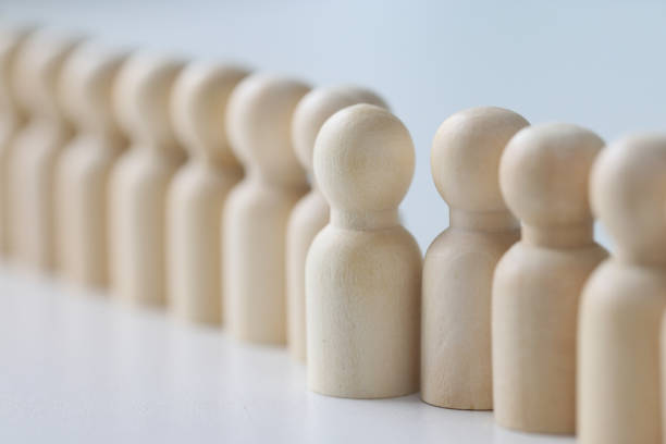 istock Small wooden figurines put in long row on white table 1775761275